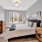 spacious master bedroom with light fixture and large windows